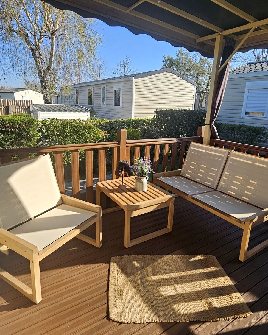 La terrasse en bois au soleil, avec son salon de jardin